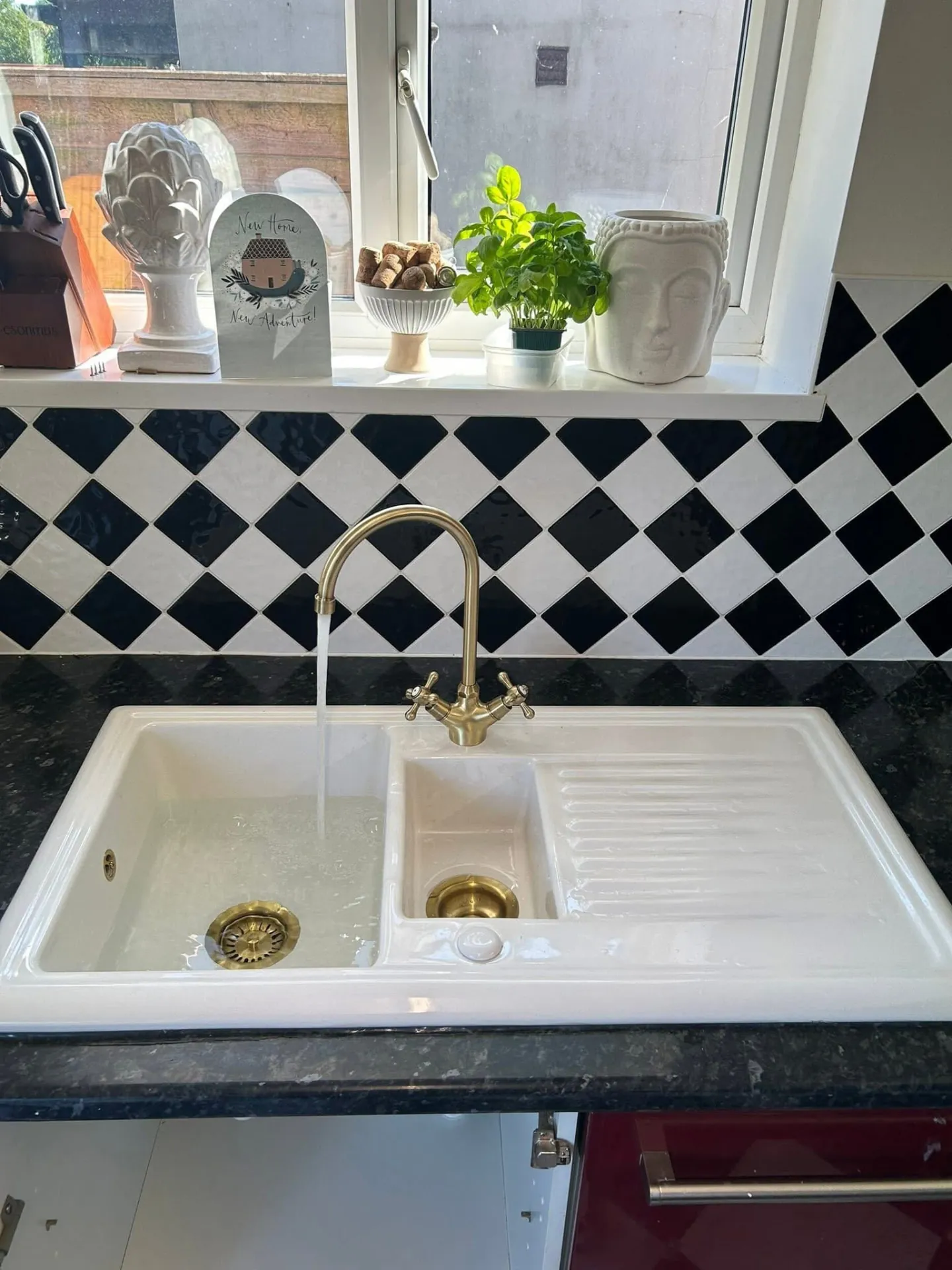Brushed brass kitchen mixer tap replaced on a ceramic sink