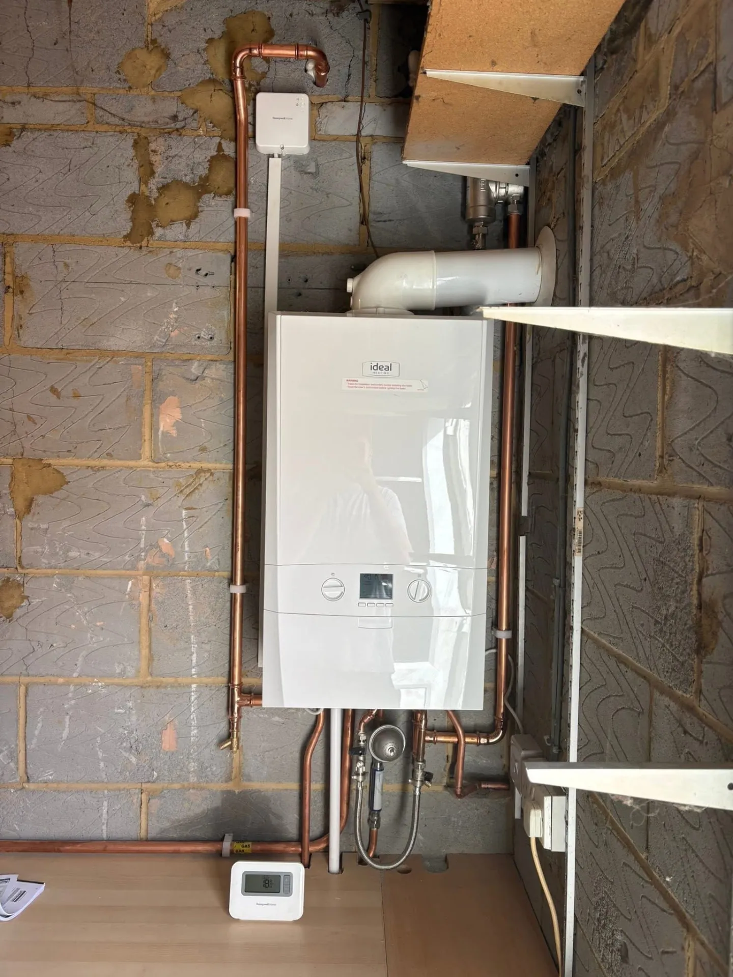 Wall-mounted boiler installed with new copper pipework and wireless thermostat