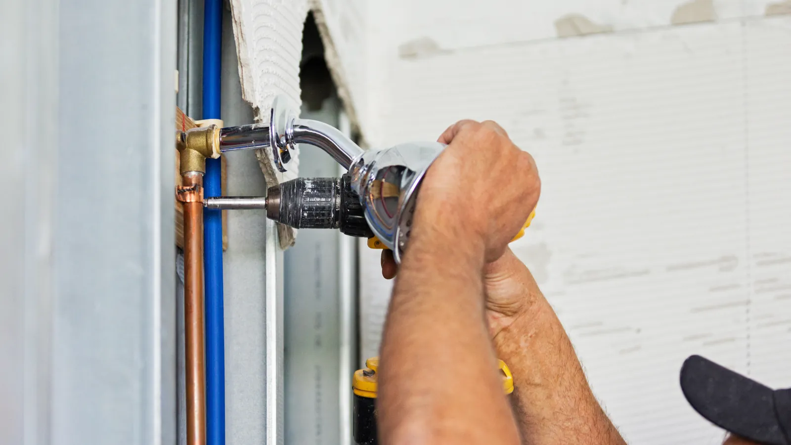 Plumber fitting a shower head to new copper and plastic supply pipework in a rental property